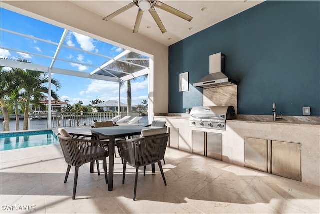 view of patio with glass enclosure, ceiling fan, an outdoor kitchen, grilling area, and a water view