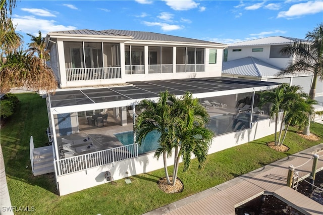 rear view of property with a yard, a patio, and a sunroom