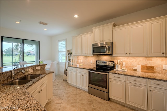 kitchen featuring white cabinetry, sink, stainless steel appliances, and light stone counters