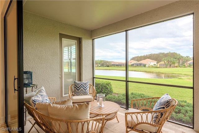 sunroom featuring a water view