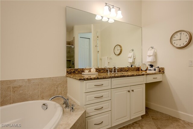 bathroom featuring tiled tub, tile patterned flooring, and vanity