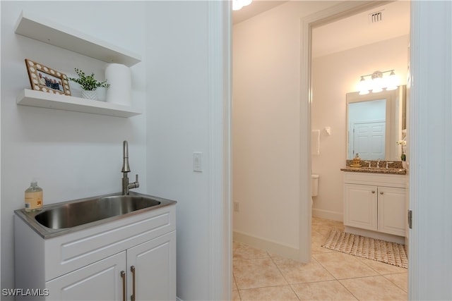 laundry area featuring sink and light tile patterned floors