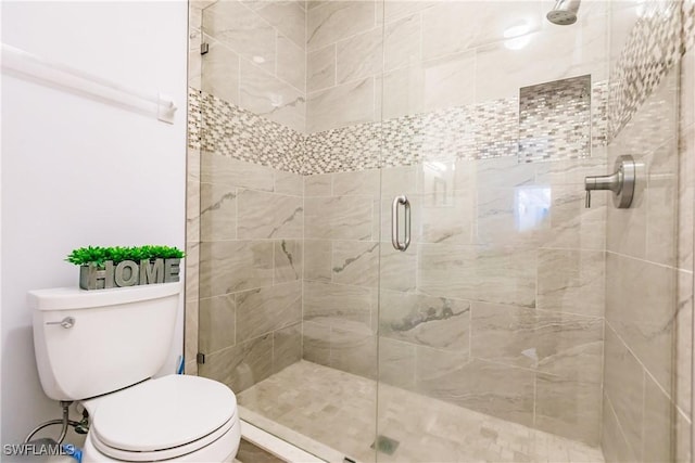 bathroom featuring an enclosed shower and toilet