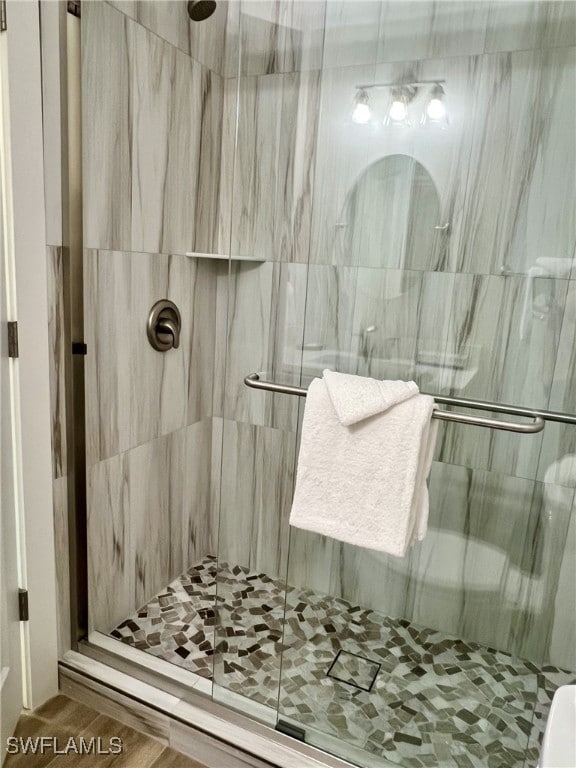 bathroom with wood-type flooring and a shower with door