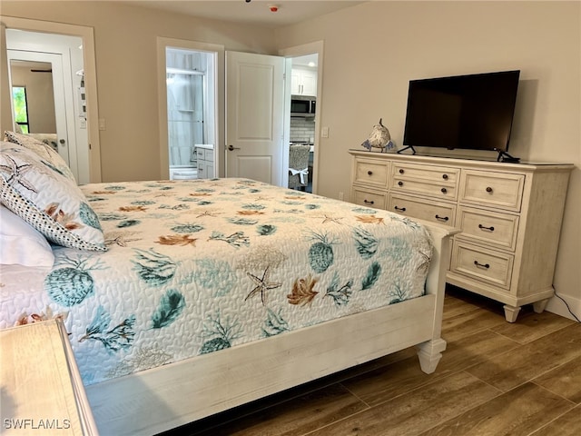 bedroom with hardwood / wood-style flooring and ensuite bath