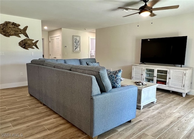 living room with hardwood / wood-style flooring and ceiling fan