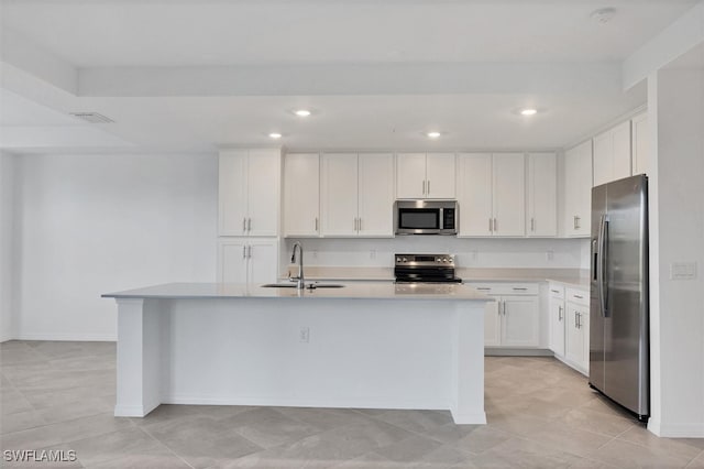 kitchen featuring sink, light tile patterned floors, a kitchen island with sink, white cabinets, and appliances with stainless steel finishes