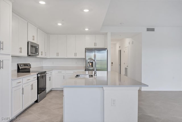 kitchen featuring sink, light tile patterned floors, an island with sink, white cabinetry, and stainless steel appliances