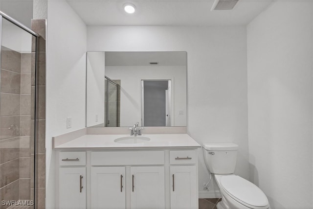 bathroom with vanity, an enclosed shower, and toilet