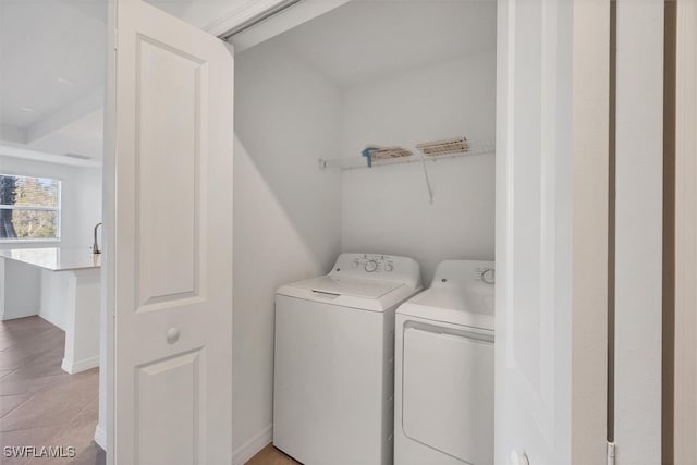 washroom with light tile patterned floors and washer and clothes dryer