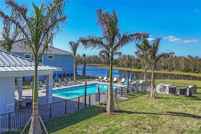 view of pool with a water view, a patio area, and a lawn