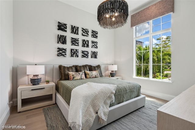 bedroom featuring light hardwood / wood-style flooring and a chandelier