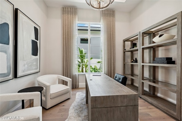 office space featuring light hardwood / wood-style floors and an inviting chandelier