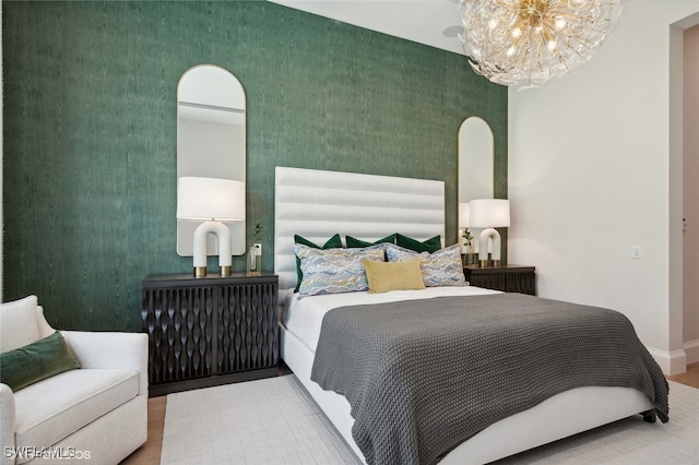 bedroom with hardwood / wood-style floors and a notable chandelier