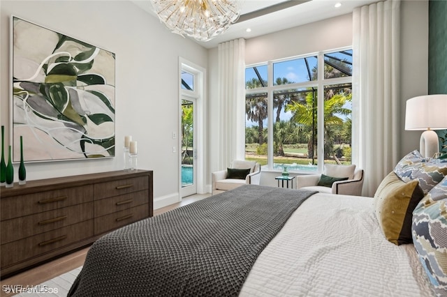 bedroom with a notable chandelier, light hardwood / wood-style floors, and access to outside