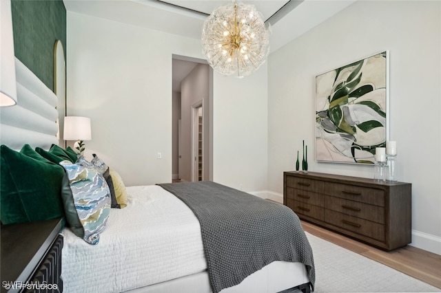 bedroom featuring a chandelier and light wood-type flooring