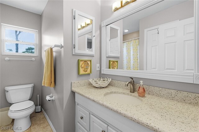 bathroom featuring tile patterned flooring, vanity, and toilet