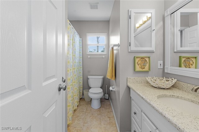 bathroom with tile patterned flooring, vanity, and toilet