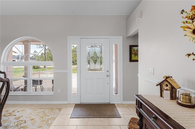 tiled entrance foyer with a healthy amount of sunlight