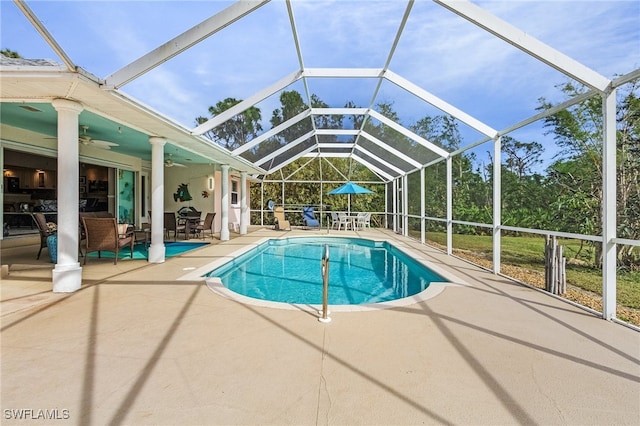 view of swimming pool featuring a lanai, ceiling fan, and a patio area