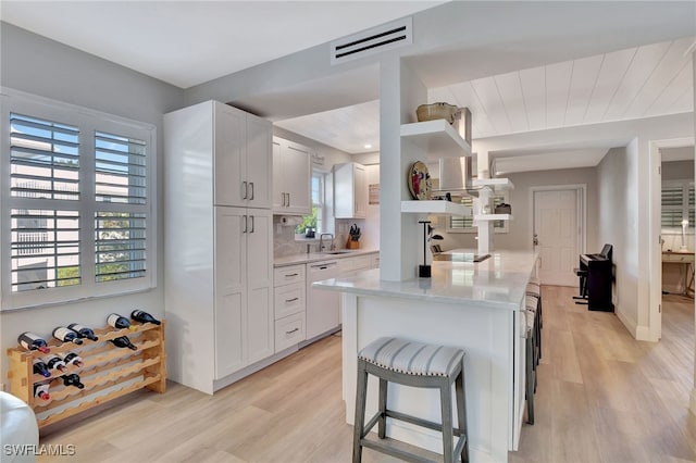 1051 3rd St S Unit 201, Naples, FL 34102 - kitchen featuring white dishwasher, open shelves, light wood-type flooring, and healthy amount of natural light