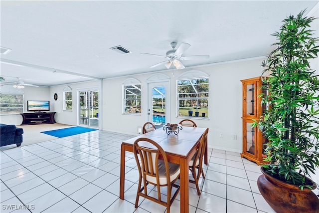 dining space featuring ceiling fan, a healthy amount of sunlight, light tile patterned flooring, and crown molding