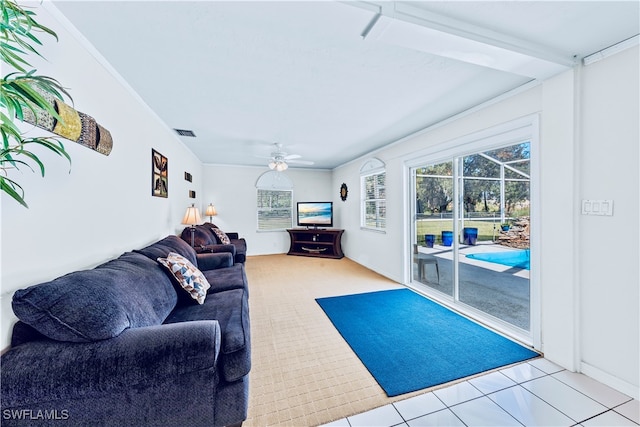 living room with ceiling fan, light tile patterned floors, and ornamental molding