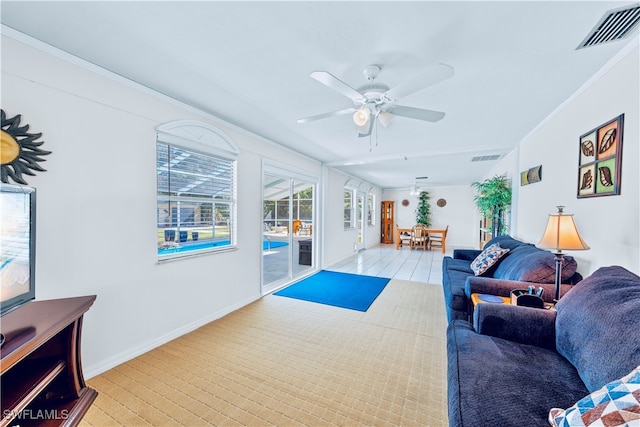 living room featuring light hardwood / wood-style floors, ceiling fan, and crown molding