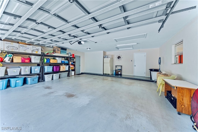 garage featuring a garage door opener and white refrigerator