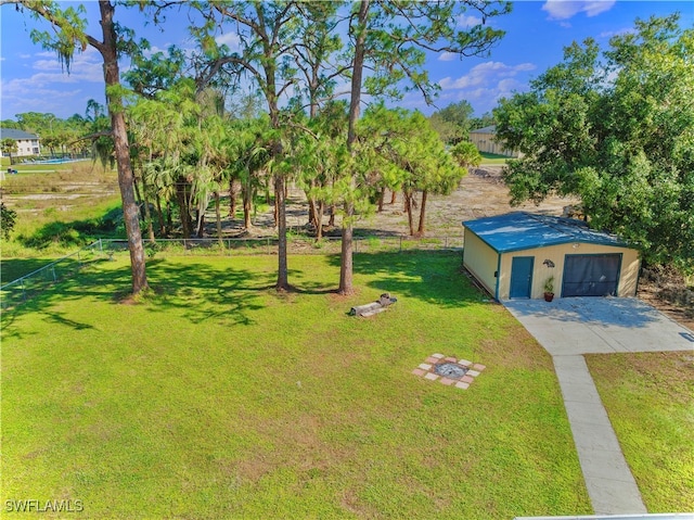 view of yard featuring a garage and an outbuilding