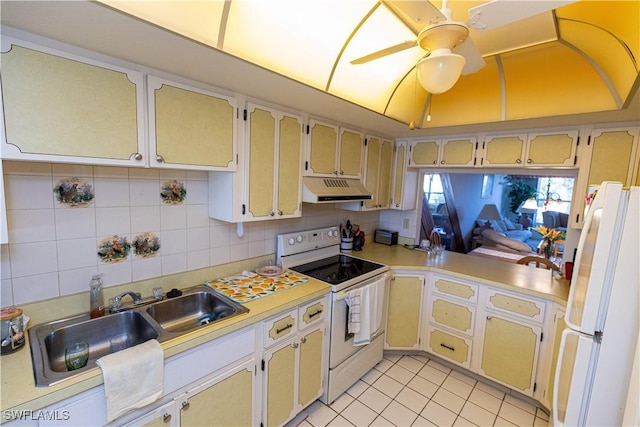 kitchen with white appliances, decorative backsplash, a ceiling fan, light countertops, and under cabinet range hood