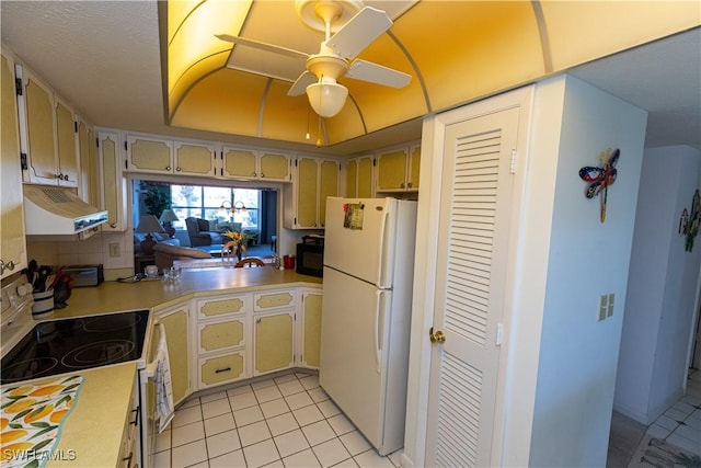 kitchen featuring ceiling fan, freestanding refrigerator, light countertops, under cabinet range hood, and black microwave