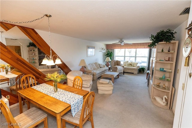 carpeted dining area featuring ceiling fan, visible vents, and a textured ceiling