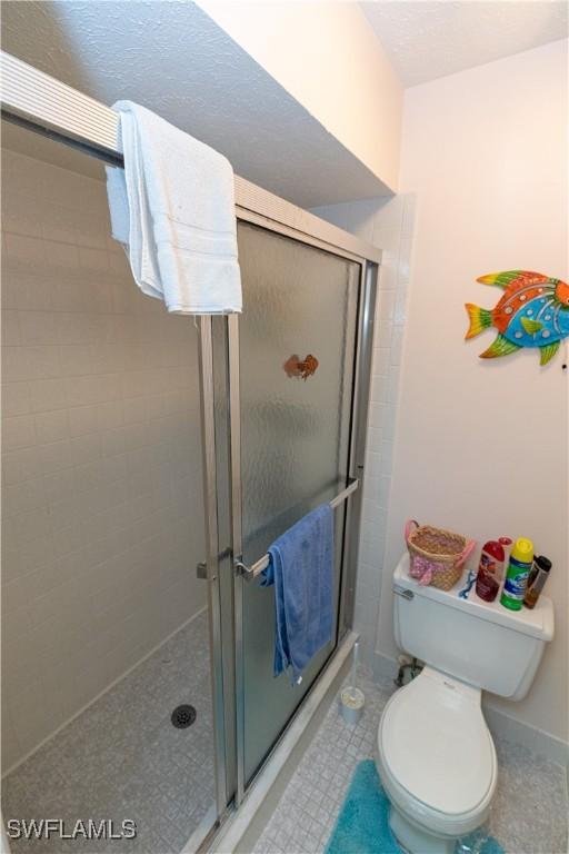 bathroom with a shower stall and toilet