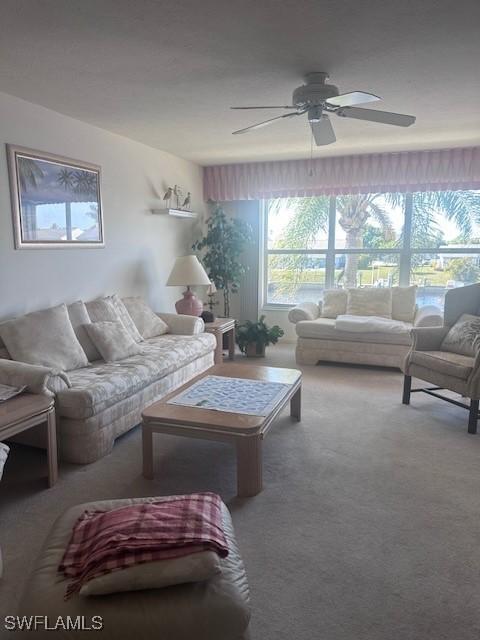 carpeted living area with a ceiling fan