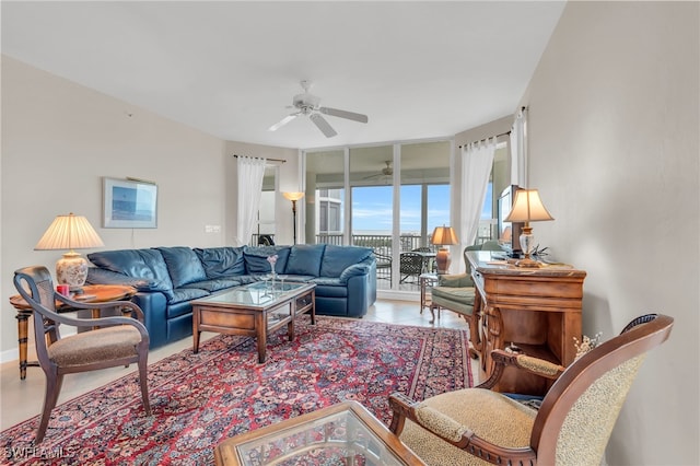 living room with ceiling fan, a wall of windows, and light tile patterned floors