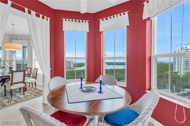 dining area with tile patterned flooring, plenty of natural light, and a water view