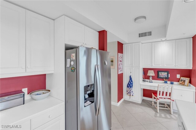 kitchen with white cabinets, built in desk, and stainless steel refrigerator with ice dispenser