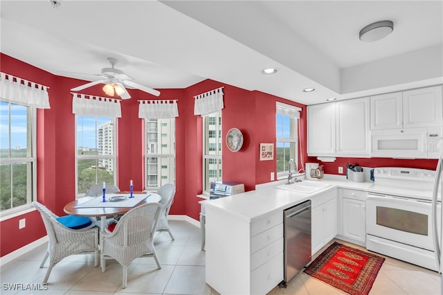 kitchen featuring white appliances, white cabinetry, a wealth of natural light, and sink