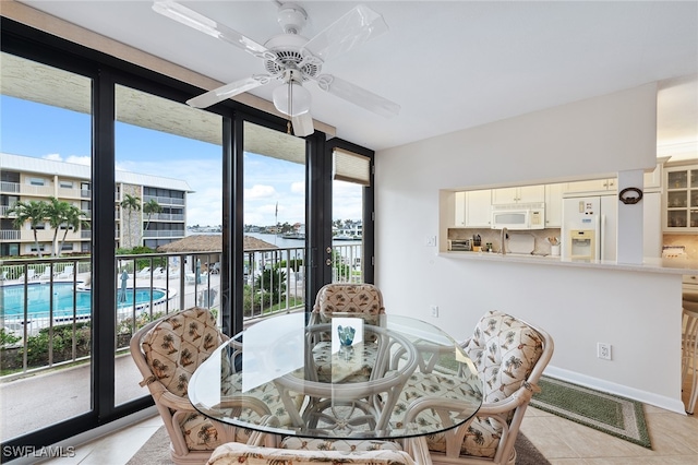 dining space featuring ceiling fan, a healthy amount of sunlight, and light tile patterned flooring