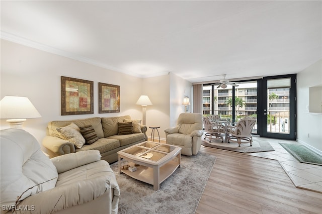 living room with french doors, crown molding, ceiling fan, light hardwood / wood-style floors, and a wall of windows