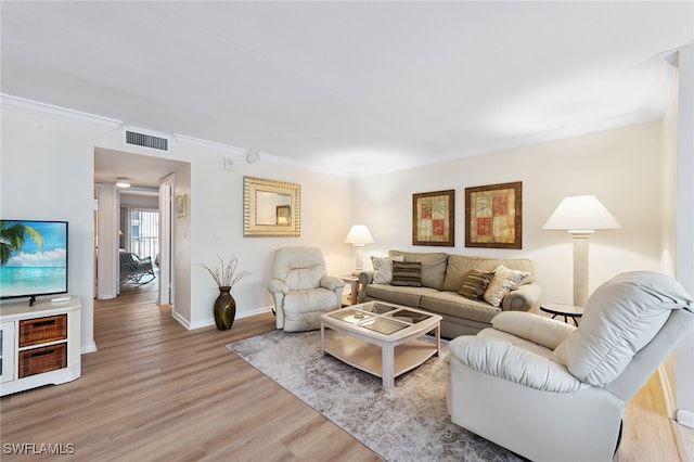 living room featuring ornamental molding and light hardwood / wood-style flooring