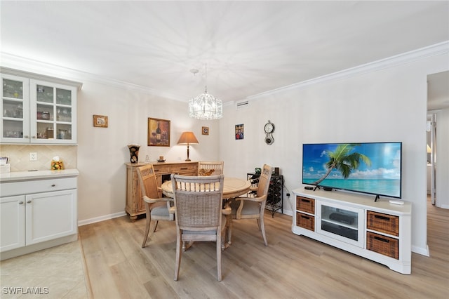 dining space featuring a chandelier, light hardwood / wood-style floors, and ornamental molding