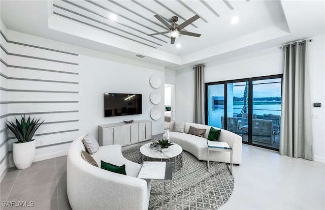 living room featuring ceiling fan and a tray ceiling