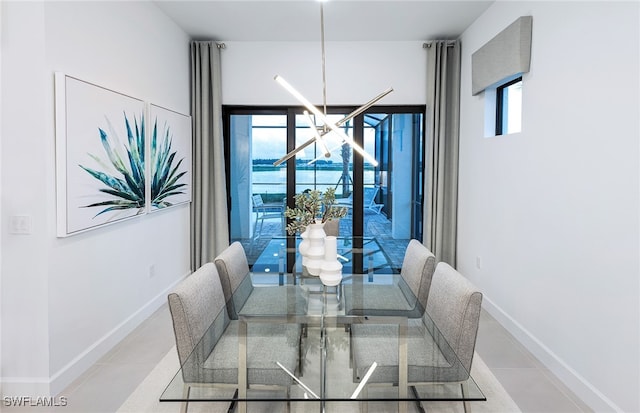 dining room with light tile patterned floors and a chandelier