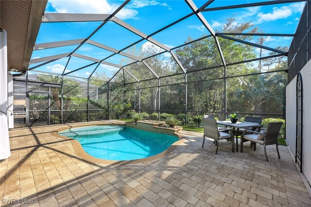 view of pool with a patio and glass enclosure