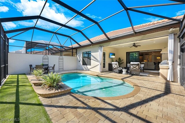 view of pool with ceiling fan, an outdoor hangout area, a patio, and glass enclosure