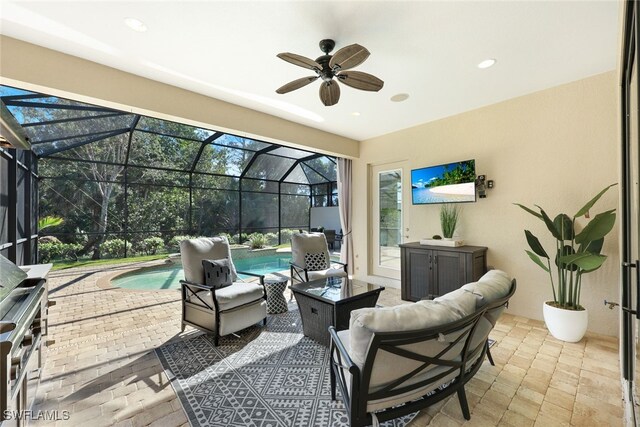 view of patio featuring glass enclosure, ceiling fan, and an outdoor hangout area