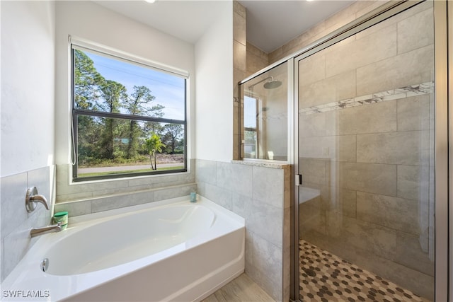 bathroom featuring independent shower and bath