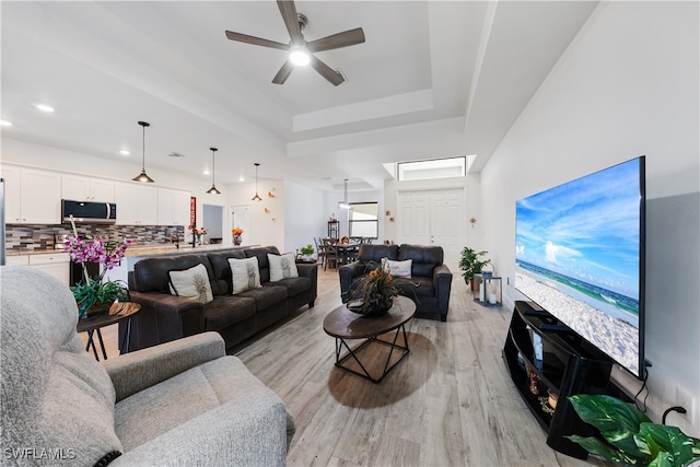 living room featuring ceiling fan and light hardwood / wood-style floors